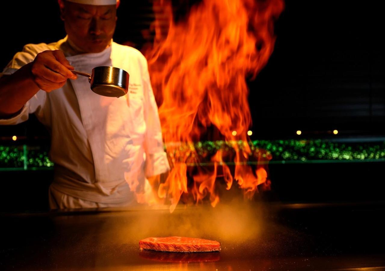 אונה Hotel Monterey Okinawa Spa & Resort מראה חיצוני תמונה A chef cooking with the technique of flambe